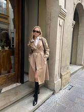 a lady wears a double-breasted trench coat